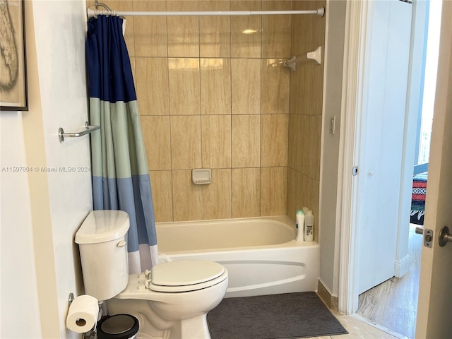 bathroom featuring shower / bathtub combination with curtain and toilet