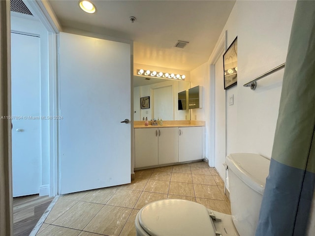 bathroom featuring oversized vanity, toilet, and tile floors