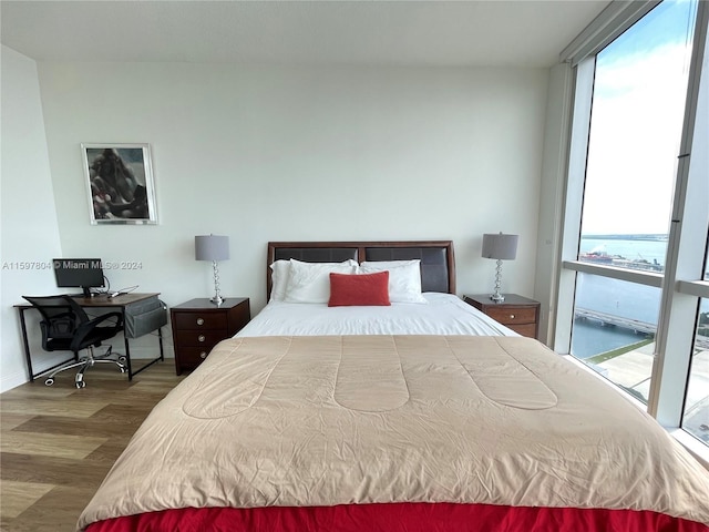 bedroom with dark wood-type flooring and access to outside