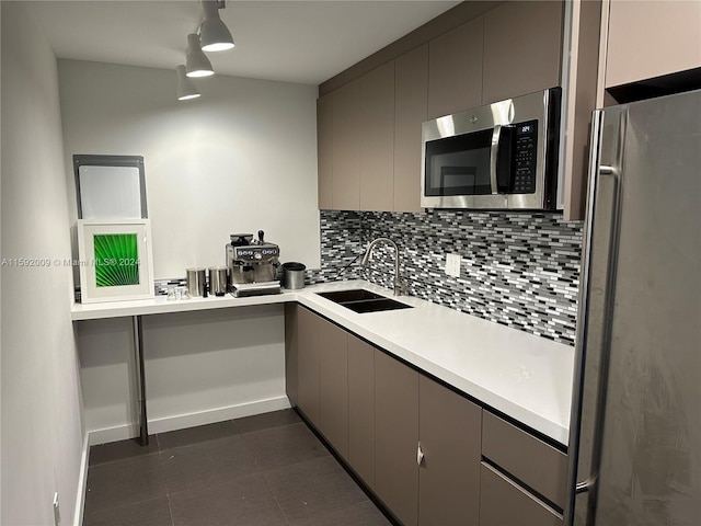 kitchen featuring decorative backsplash, stainless steel appliances, gray cabinetry, and sink