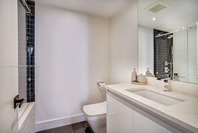 bathroom with tile patterned floors, vanity, toilet, and tiled shower