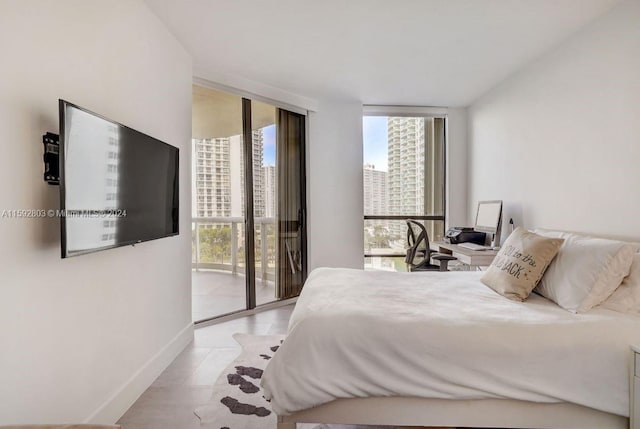 bedroom featuring access to exterior, light tile patterned floors, and floor to ceiling windows