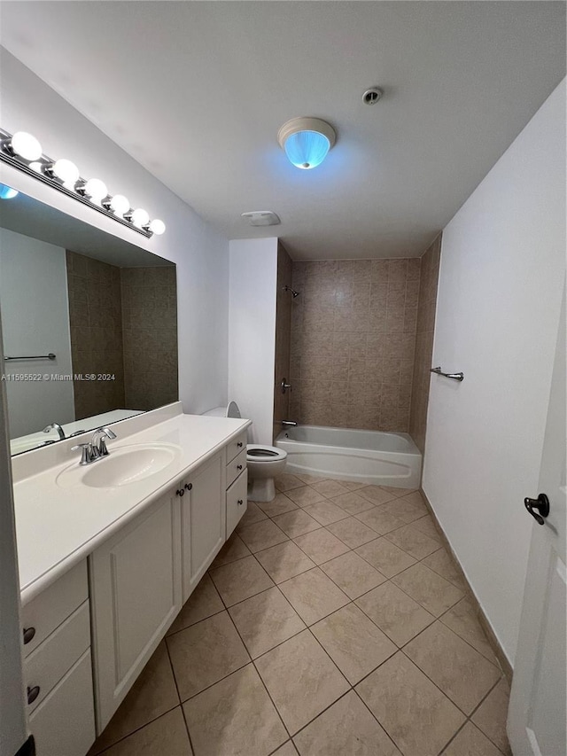 full bathroom featuring tile patterned flooring, vanity, toilet, and tiled shower / bath