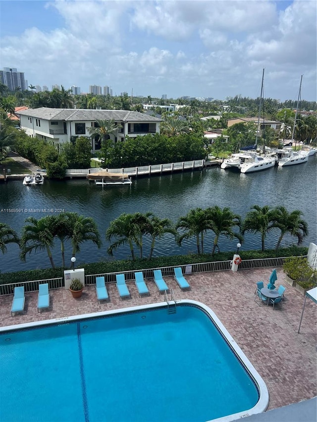 view of swimming pool featuring a patio and a water view