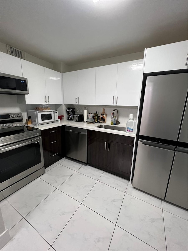 kitchen featuring white cabinetry, appliances with stainless steel finishes, and sink