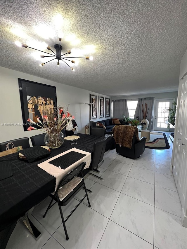 dining area featuring an inviting chandelier and a textured ceiling