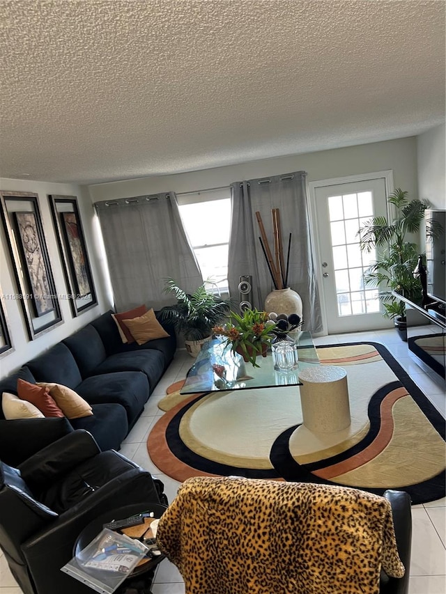 living room featuring a textured ceiling and light tile patterned floors