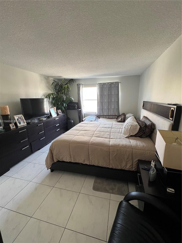 bedroom featuring a textured ceiling and light tile patterned floors