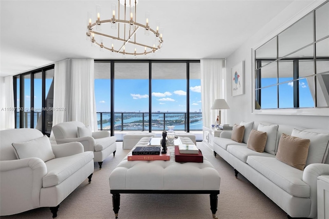 living room with plenty of natural light, a notable chandelier, a wall of windows, and a water view