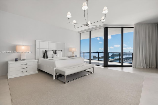 bedroom with access to outside, an inviting chandelier, floor to ceiling windows, and a water view