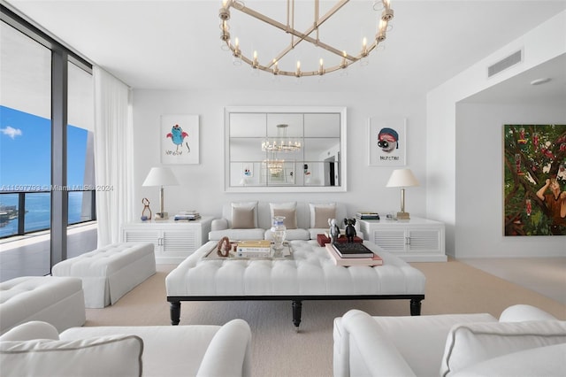 carpeted living room with a notable chandelier and a water view