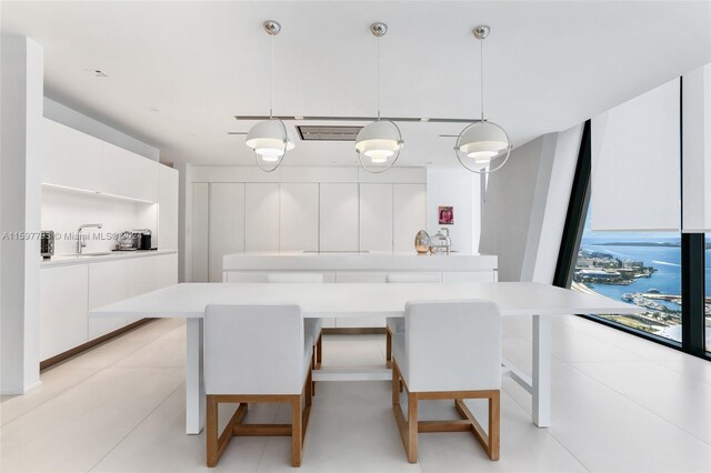 kitchen featuring white cabinetry, light tile patterned floors, pendant lighting, and a kitchen island