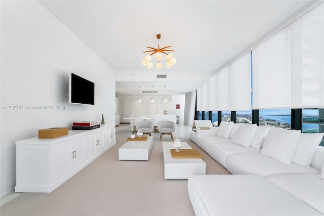 living room featuring light carpet, expansive windows, and a chandelier