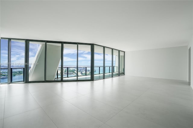 spare room featuring tile patterned floors and a wall of windows