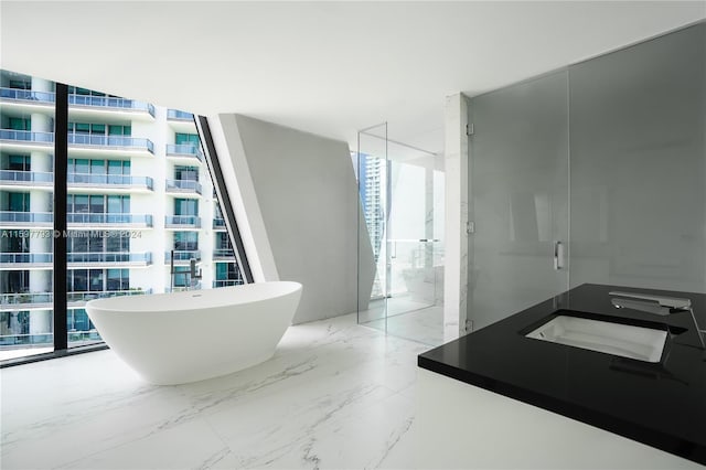 bathroom featuring sink, plus walk in shower, tile patterned floors, and expansive windows