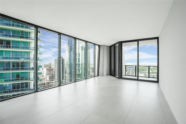 spare room featuring expansive windows and light tile patterned flooring