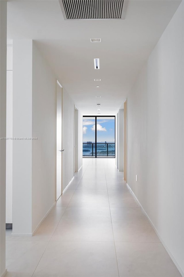 corridor featuring a wall of windows and light tile patterned floors