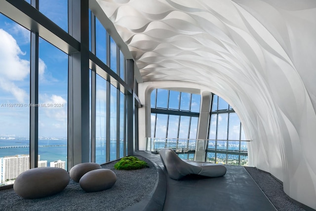 bedroom with multiple windows and a water view