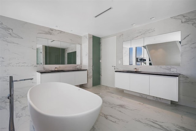 bathroom with a washtub, tile patterned floors, and vanity