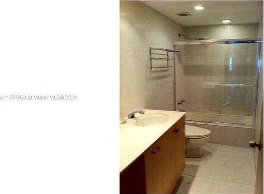 full bathroom with tile patterned flooring, toilet, combined bath / shower with glass door, and vanity