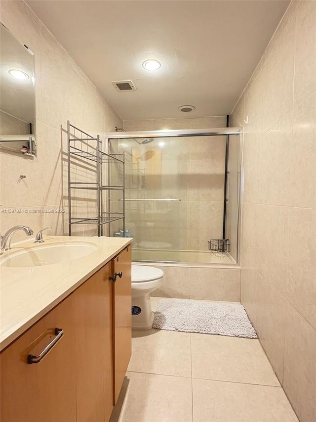 1965 S Ocean Dr Unit 2F, Hallandale Beach, FL 33009 - bathroom featuring tile walls, toilet, tile patterned floors, vanity, and tiled shower / bath