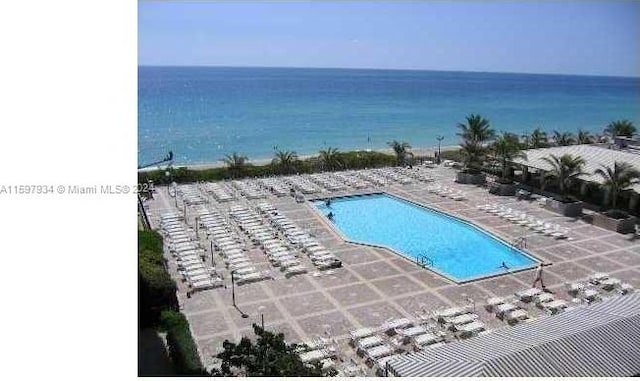 view of pool featuring a patio area and a water view