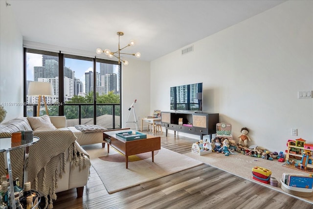 living room featuring a notable chandelier, floor to ceiling windows, and wood-type flooring