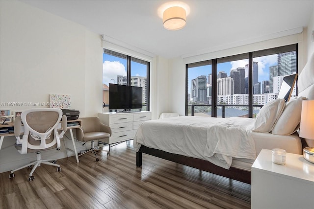 bedroom featuring wood-type flooring, access to outside, and multiple windows