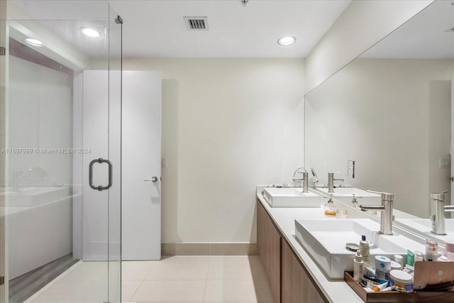 bathroom featuring tile patterned flooring, vanity, and a shower with door