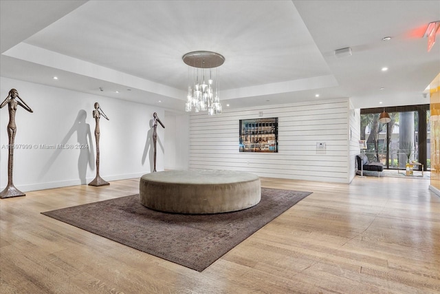 interior space featuring hardwood / wood-style floors, a tray ceiling, and wood walls