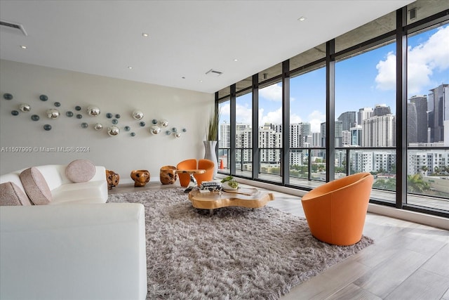 living room with light hardwood / wood-style floors and a wall of windows