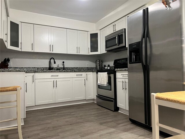 kitchen with stainless steel appliances, dark hardwood / wood-style flooring, sink, and white cabinets
