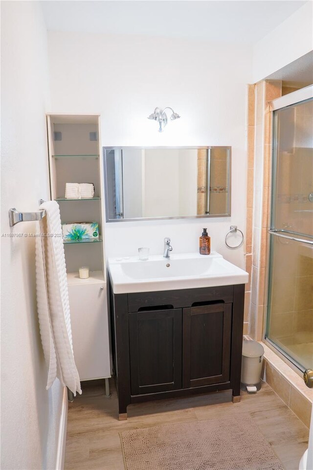 bathroom with wood-type flooring, vanity, and walk in shower