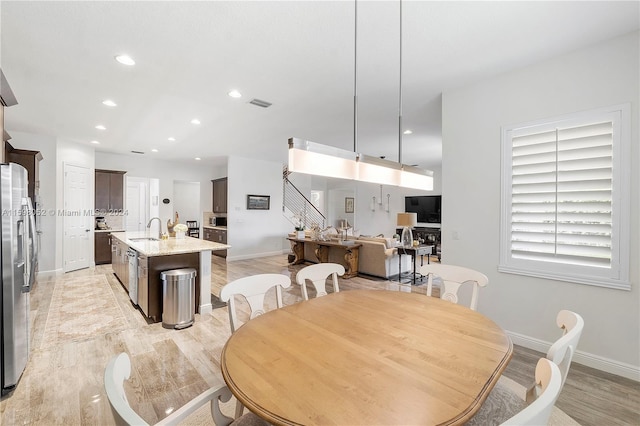 dining area with light wood-type flooring and sink