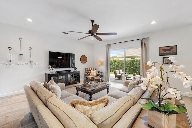 living room featuring light hardwood / wood-style floors and ceiling fan