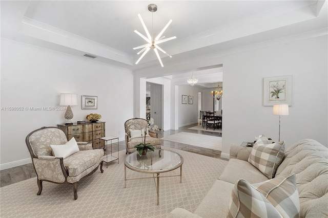 carpeted living room with a notable chandelier and a tray ceiling