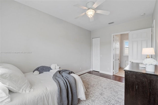 bedroom featuring ceiling fan, dark hardwood / wood-style floors, ensuite bathroom, and a closet