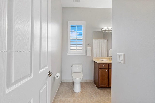 bathroom with tile patterned flooring, vanity, and toilet