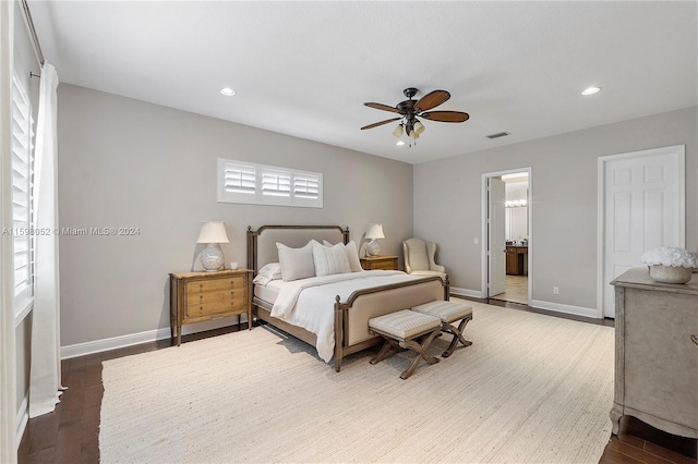 bedroom with ceiling fan, dark hardwood / wood-style flooring, and connected bathroom