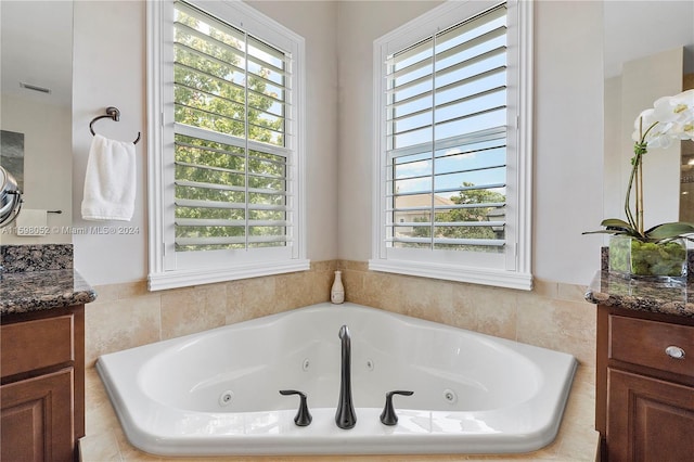 bathroom featuring vanity and tiled bath