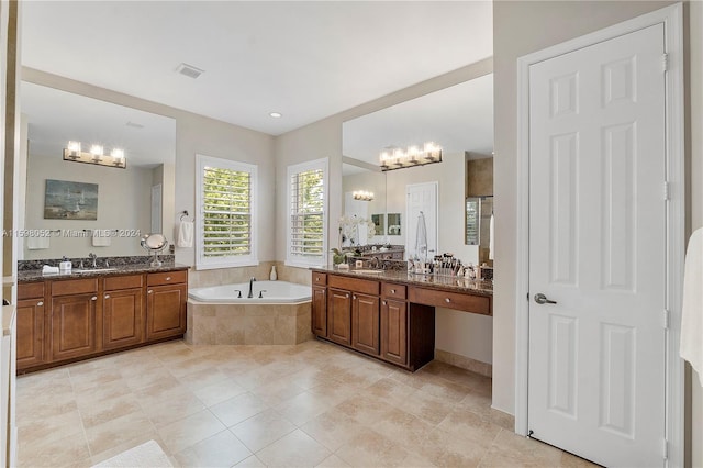 bathroom featuring tiled tub, tile patterned flooring, and vanity