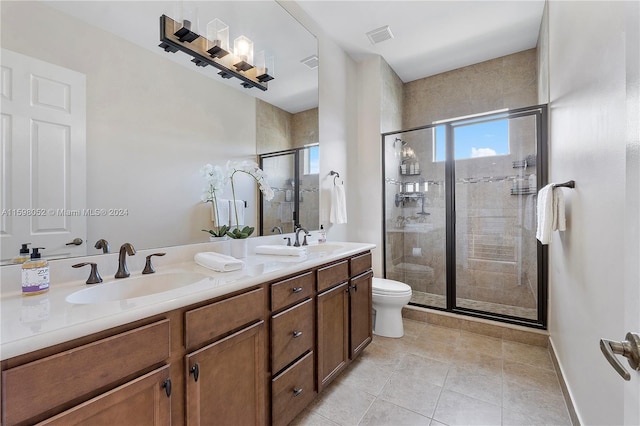 bathroom with tile patterned flooring, a shower with door, vanity, and toilet