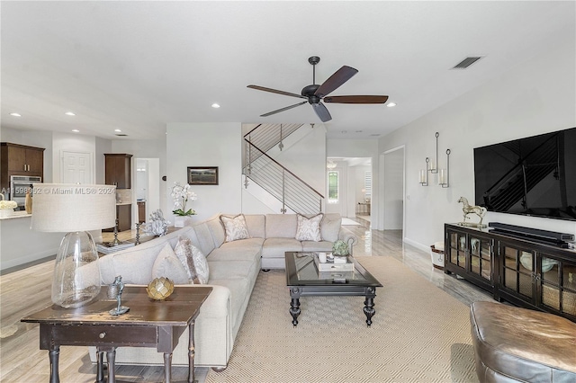 living room featuring light hardwood / wood-style floors and ceiling fan