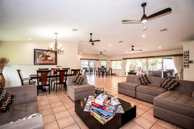 living room with ceiling fan with notable chandelier, lofted ceiling, and light tile patterned flooring