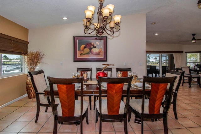 dining room with lofted ceiling, light tile patterned floors, and ceiling fan with notable chandelier