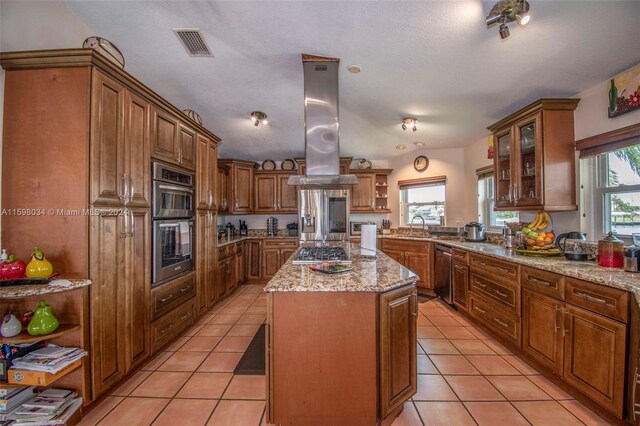 kitchen featuring island exhaust hood, appliances with stainless steel finishes, a center island, and a healthy amount of sunlight