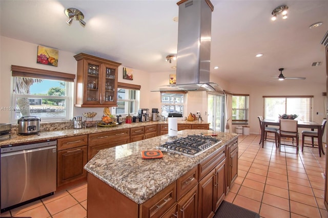 kitchen featuring a wealth of natural light, island range hood, a kitchen island, and stainless steel appliances