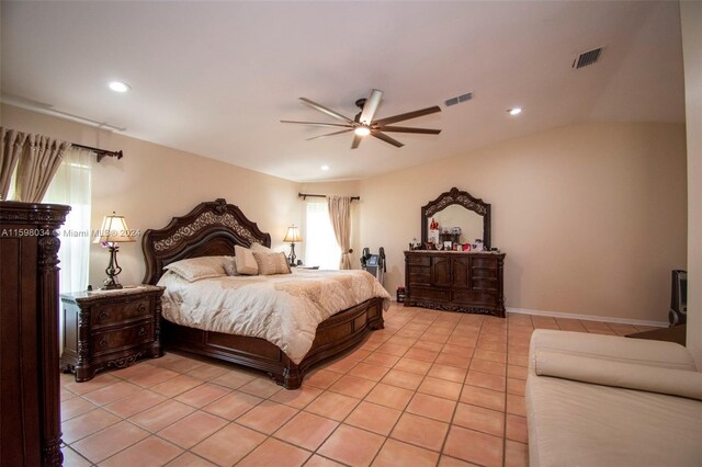 bedroom featuring ceiling fan, light tile patterned floors, and lofted ceiling