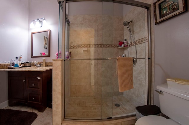 bathroom with tile patterned flooring, vanity, toilet, and walk in shower