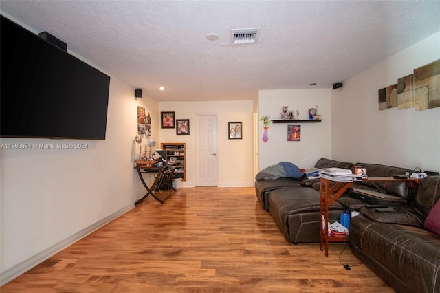 living room with light hardwood / wood-style floors and a textured ceiling